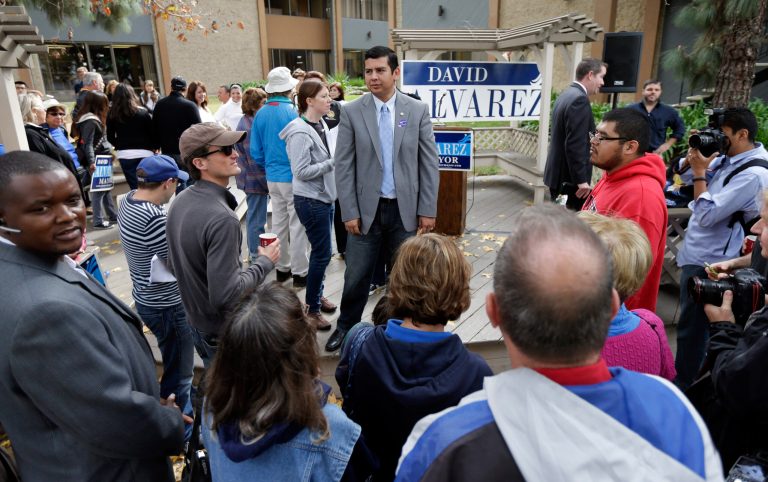 David Alvarez, above center, a San Diego city councilman and Democratic candidate for mayor, looks on as he meets with supporters Tuesday, Nov. 19, 2013, in San Diego. San Diegans head to the polls Tuesday to choose a new mayor, after Bob Filner's resignation amid allegations of sexual harassment has left the city with an interim mayor. (AP Photo/Gregory Bull)