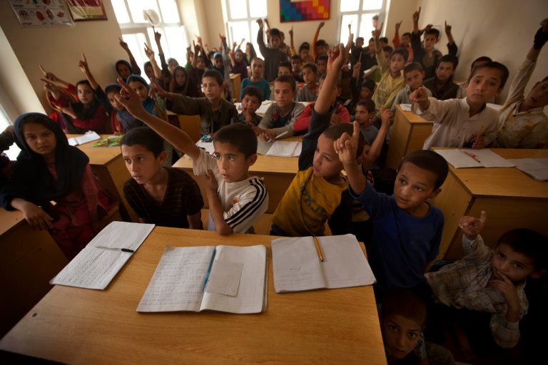FILE - In this July 26, 2011 file photo, Afghan street children raise their hands to answer the question posed to them by their teacher at Ashiana centre in Kabul, Afghanistan. At least 250 million of the world's 650 million primary school age children are unable to read, write or do basic mathematics, according to a report Wednesday, Jan. 29, 2014, commissioned by UNESCO, the U.N. Educational, Scientific and Cultural Organization. It estimated that 14 countries had more than one million children out of school in 2011 including Afghanistan, China, Congo, Somalia, Sudan before its break-up, and Tanzania. (AP Photo/Dar Yasin, File)