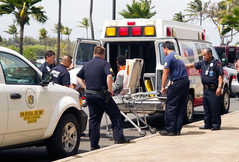A 15-year-old boy, seen sitting on a stretcher center, who stowed away in the wheel well of a flight from San Jose, Calif., to Maui is loaded into an ambulance at Kahului Airport in Kahului, Maui, Hawaii Sunday afternoon, April 20, 2014. The boy survived the trip halfway across the Pacific Ocean unharmed despite frigid temperatures at 38,000 feet and a lack of oxygen, FBI and airline officials said. FBI spokesman Tom Simon in Honolulu told The Associated Press on Sunday night that the boy was questioned by the FBI after being discovered on the tarmac at the Maui airport with no identification. 