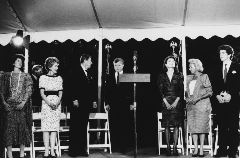 President Ronald Reagan and first lady Nancy Reagan stand on stage with members of the Kennedy clan during a fund raising event for the John F. Kennedy Memorial Library, June 24, 1985, at Sen. Edward Kennedy's McLean, Va., home. From left: Caroline Kennedy, daughter of the late president, Mrs. Reagan, Reagan, Sen. Kennedy, Jacqueline Kennedy Onassis, wife of the late president, Ethel Kennedy, wife of the late Robert F. Kennedy, and John Kennedy, Jr., son of the late president. (AP Photo/Charles Tasnadi)