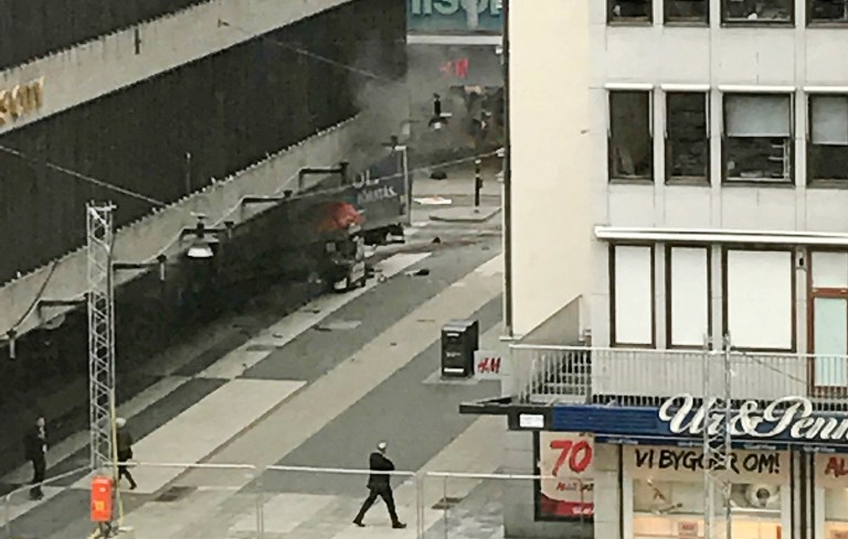 People look on at the scene after a truck crashed into a department store injuring several people in central Stockholm, Sweden. (Andreas Schyman, TT News Agency via AP)