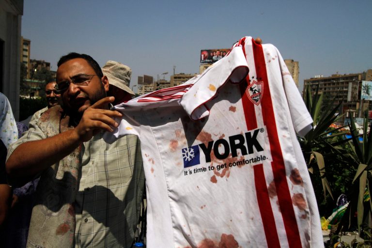 A man displays a bloodied shirt of ousted President Mohamed Morsi's supporter outside a local hospital in Cairo on Monday. (AP/Nasser Shiyoukhi)