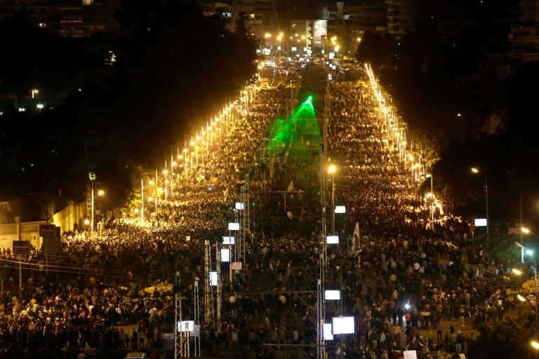   Egyptian protesters gather outside the presidential palace after they broke through a barbed wire barricade that was keeping them from getting closer to the presidential palace, in Cairo, Egypt, Friday, Dec. 7, 2012. Egypt's political crisis spiraled deeper into bitterness and recrimination Friday as thousands of Islamist backers of the president vowed vengeance at a funeral for men killed in bloody clashes earlier this week and large crowds of the president's opponents marched on his palace to increase pressure after he rejected their demands. (AP Photo/Hassan Ammar)  