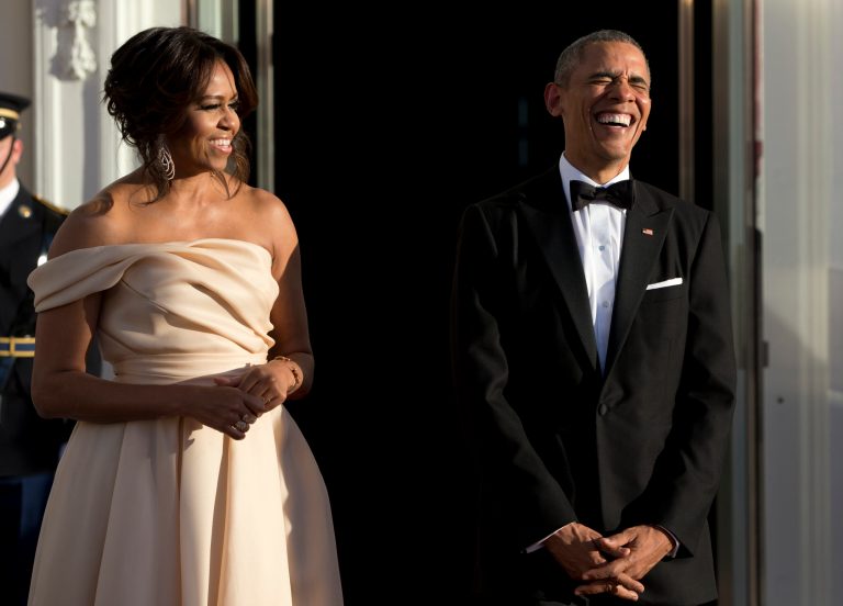 President Barack Obama and first lady Michelle Obama laugh together as as they wait for Nordic Leaders to arrive at the North Portico of the White House Friday for a State Dinner. (AP Photo/Carolyn Kaster)
