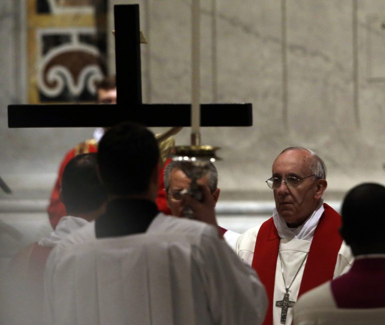 Pope Francis, right, looks up to the Crucifix during the Passion of Christ Mass inside St. Peter's Basilica, at the Vatican, Friday, March 29, 2013. Pope Francis began the Good Friday service at the Vatican with the Passion of Christ Mass and hours later will go to the ancient Colosseum in Rome for the traditional Way of the Cross procession. (AP Photo/Gregorio Borgia)