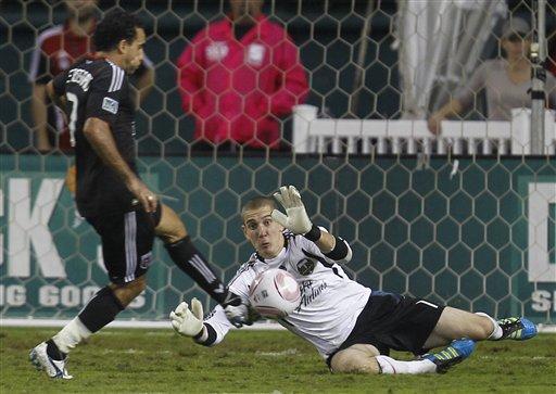 D.C. United's Dwayne De Rosario, left, strikes the ball as Portland Timbers goalkeeper Troy Perkins defends during the second half of an MLS soccer game, Wednesday, Oct. 19, 2011, in Washington. The game ended in a 1-1 tie. 