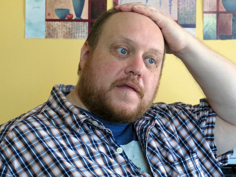 Tom Ptacek sits in his office where he works as an advocate for homeless people in Portland, Maine. Ptacek, a U.S. Navy veteran, is among thousands of Mainers who stand to lose state health care coverage at the end of the year because of changes to the stateâs program and the decision not to expand coverage under the federal health care overhaul. (AP/Clarke Canfield)
