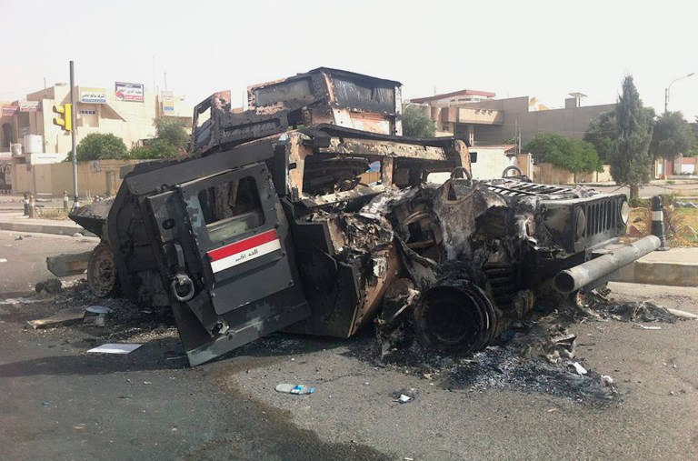 An Iraqi army armored vehicle is seen burned on a street of the northern city of Mosul, Iraq, Thursday. (AP)