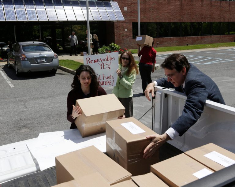 Jessica Azulay of Alliance for a Green Economy, left, and Keith Schue of Sustainable Otsego unload boxes of comments at the New York State Energy Research and Development Authority offices on Friday, May 30, 2014, in Albany, N.Y. The comments, filed on the deadline for responding to the draft state energy plan issued in January, urge New York officials to reject additional natural gas drilling as any sort of environmental solution, calling instead for a much stronger push for renewable and cleaner solar and wind power. (AP Photo/Mike Groll)
