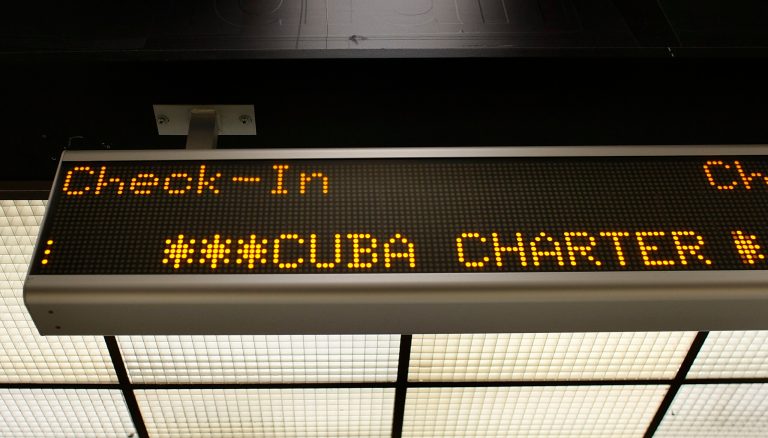 A check-in sign for the ABC Charter flight to Cuba is seen at Miami International Airport on April 7, 2009 in Miami, Florida. (Photo by Joe Raedle/Getty images File)