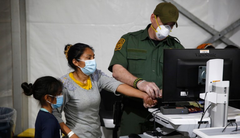 A migrant and her daughter have their biometric data entered at the intake area of the U.S. Department of Homeland Security's holding facility, the main detention center for unaccompanied children in the Rio Grande Valley, in Donna, Texas.