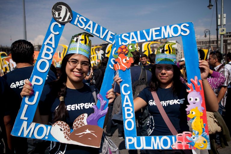   FILE - In this June 4, 2012 file photo, Greenpeace activists pose for pictures with signs that read in Spanish 