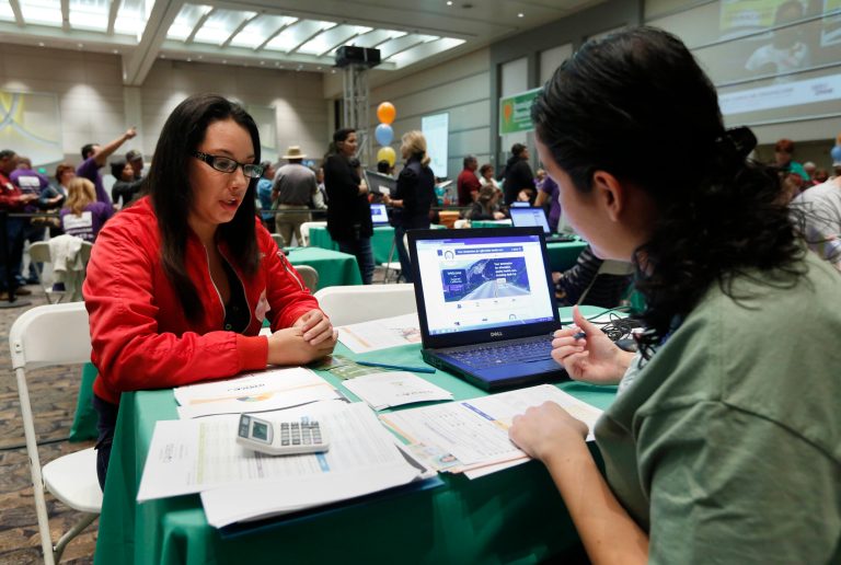 A woman gets help signing up for health insurance from a health care specialist in Sacramento, Calif., on Nov. 9.ÃÂ (AP Photo/Rich Pedroncelli)