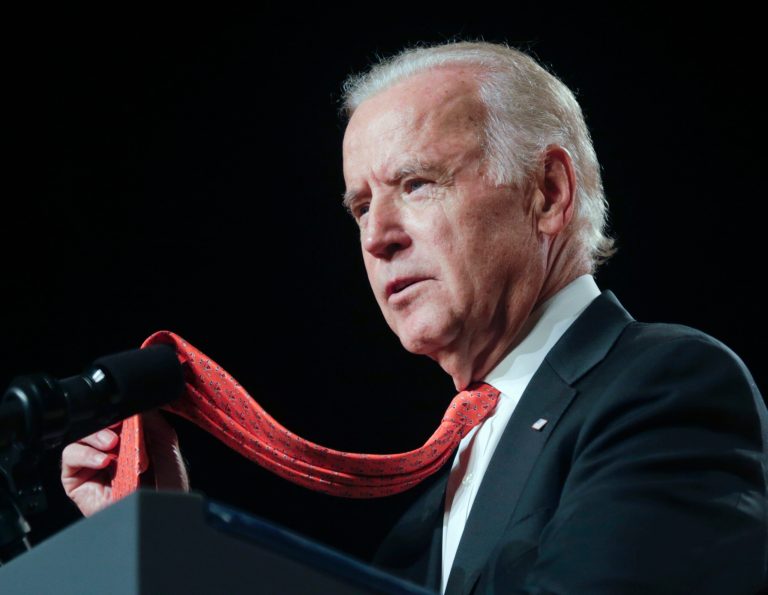 Vice President Joe Biden, who graduated from Syracuse Law School, holds his orange tie as he speaks at Syracuse University during an 