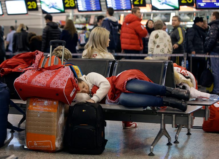 A passenger sleeps while waiting for a flight at the Sochi Airport following the 2014 Winter Olympics, Monday, Feb. 24, 2014, in Sochi, Russia. (AP Photo/Darron Cummings)
