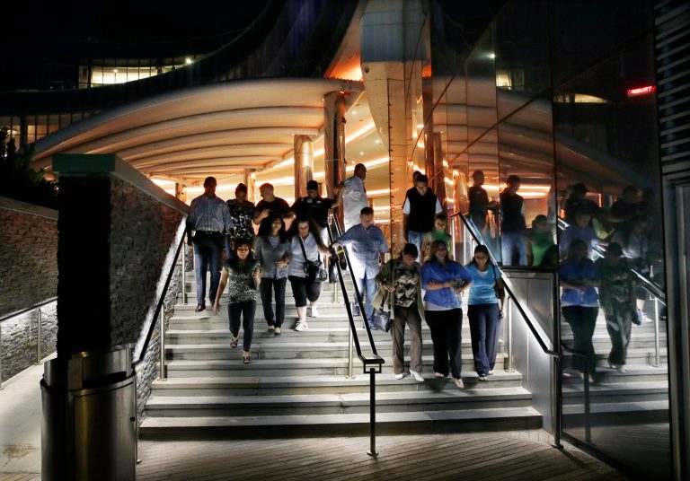 Casino workers and customers walk out of The Revel Hotel Casino together early in the morning Tuesday, Sept. 2, 2014, in Atlantic City, N.J.  The casino section of the Revel closed at 6:30 a.m.Tuesday. Revel is shutting down a little over two years after opening with high hopes of revitalizing Atlantic City's struggling gambling market. (AP Photo/Mel Evans)