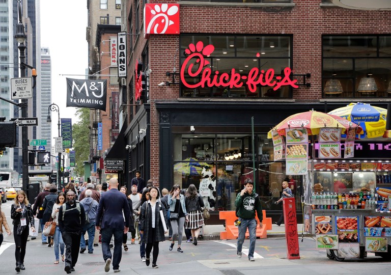 People walk past a new Chick-fil-A restaurant, Thursday, Oct. 1, 2015 in New York. The Atlanta-based privately held franchise company has more than 1900 restaurants in 41 states and Washington, D.C. The New York franchise, located a few blocks from Times Square, opens Saturday, Oct. 3, marking its push to become a bigger national player. (AP Photo/Mark Lennihan)