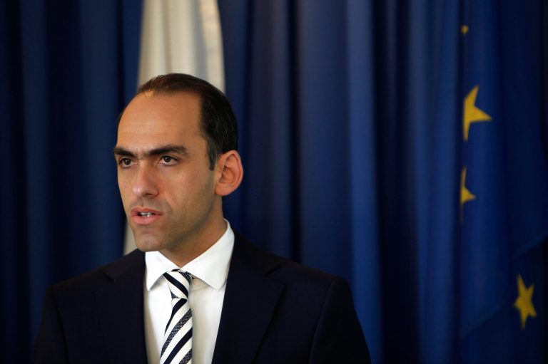 Cyprus' Financial minister Harris Georgiades speaks to the media during a press conference at the financial Ministry in Nicosia Saturday May 17, 2014. Georgiades says international creditors have given a fourth straight positive review to the country's financial rescue program and are projecting that its economy will shrink this year slightly less than earlier forecasts. (AP Photo/Petros Karadjias)