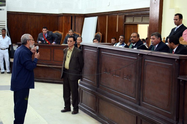 Muslim Brotherhood leader Mohammed Badie speaks before judge after getting out of a defendant cage during his trial in Cairo, Egypt, Sunday, May 18, 2014. The judge said he would announce a verdict on June 7 in a case involving Badie and 47 other defendants charged with cutting off a major road north of Cairo as part of a wave of post-Morsi protests last summer. (AP Photo/Ahmed Gamil)