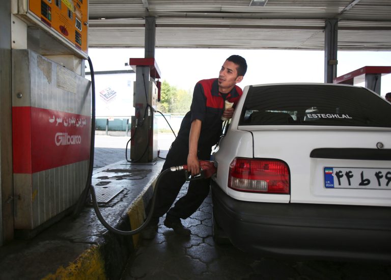 A gas station worker fills a car in central Tehran, Iran, Friday, April 25, 2014.  The Iranian government on Friday cut a portion of fuel subsidies, nearly doubling some prices at the pump as part of a second round of cuts delayed since 2012. (AP Photo/Vahid Salemi)