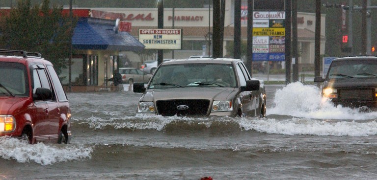   Cars make their way through floodwaters on Brent Lane following heavy rains Saturday, June 9, 2012, in Pensacola, Fla. The National Weather Service said 13.11 inches fell on Pensacola over 24 hours by Saturday, coming close to the city's all-time record of 15.29 inches set in 1934, causing what could be millions of dollars in flood damage in the Pensacola area alone with more rain on the way. (AP Photo/The Pensacola News Journal, Bruce Graner) NO SALES  