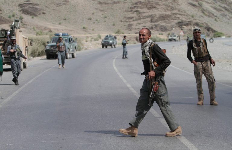 Afghan policeman take up positions on a road near the scene of an attack by militants in the Torkham area in Jalalabad province east of Kabul, Afghanistan. (AP/Rahmat Gul)