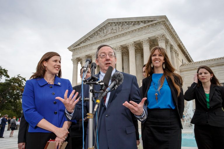 Attorney Douglas Laycock, center, characterizes his argument before the Supreme Court on behalf of an Arkansas prison inmate who says his Muslim beliefs that require him to grow a beard are being violated by prison rules that prevent beards, Tuesday, in front of the court in Washington. (AP Photo/J. Scott Applewhite)