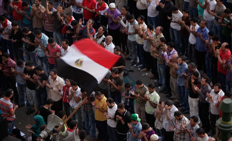   Egyptian protesters perform prayers in front of a national flag, during a protest at Tahrir Square, Cairo, Egypt, Friday, June 8, 2012. Hundreds gathered in Cairo's Tahrir Square, the focal point of Egyptian uprising, to demonstrate against presidential candidate Ahmed Shafiq, Hosni Mubarak's last prime minister, ahead of a run-off vote. (AP Photo/Amr Nabil)  