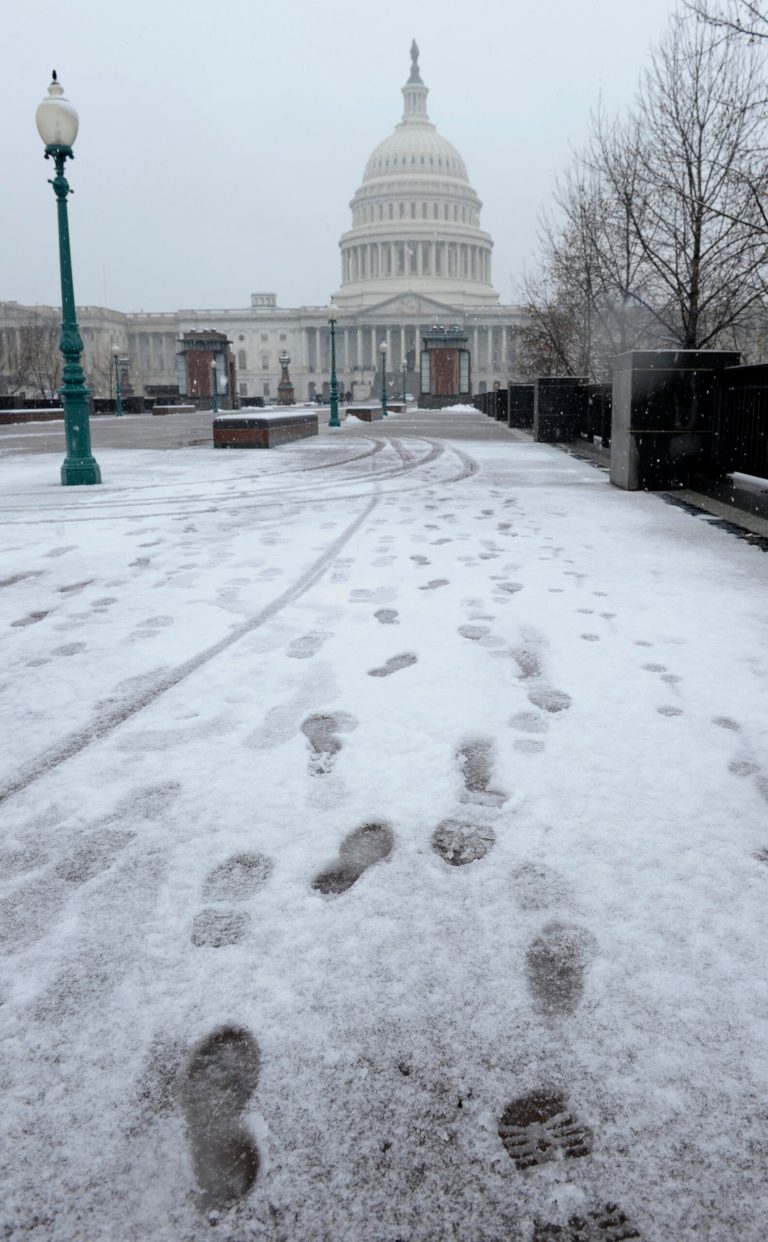 Footprints in the snow lead to the Capitol in Washington, Tuesday, Dec. 10, 2013. In Washington. Snow was falling at daybreak, but traffic problems failed to materialize as many workers stayed home. Non-emergency federal employees were granted an excused absence and others were told to telecommute, according to the U.S. Office of Personnel Management. (AP Photo/Susan Walsh)
