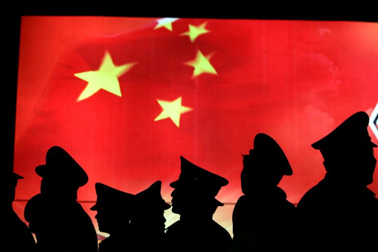 Security guard walk past the Chinese national flag at the Military Museum of Chinese People's Revolution on March 1, 2008 in Beijing, China. (Photo by China Photos/Getty images)