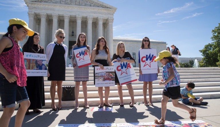 A group from the Concerned Women for America, a Christian women's activist group, shows their support as the Supreme Court ruled 7-2 for Trinity Lutheran Church of Columbia, Mo., that churches have the same right as other charitable groups to seek state money for new playground surfaces and other non-religious needs, Monday, June 26, 2017, in Washington. (AP Photo/J. Scott Applewhite)