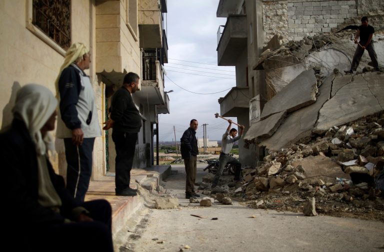   Syrian men use sledgehammers to break the concrete of a residential building destroyed in a government airstrike, while searching for belongings under the rubble, in Maaret Misreen, near Idlib, Syria, Wednesday, Dec. 12, 2012. (AP Photo/Muhammed Muheisen)  