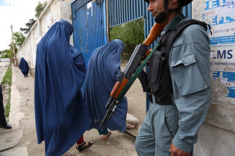 An Afghan policeman stands guard at a gate to a polling station in Jalalabad, east of Kabul, Afghanistan, on Saturday. (AP Photo/Rahmat Gul)