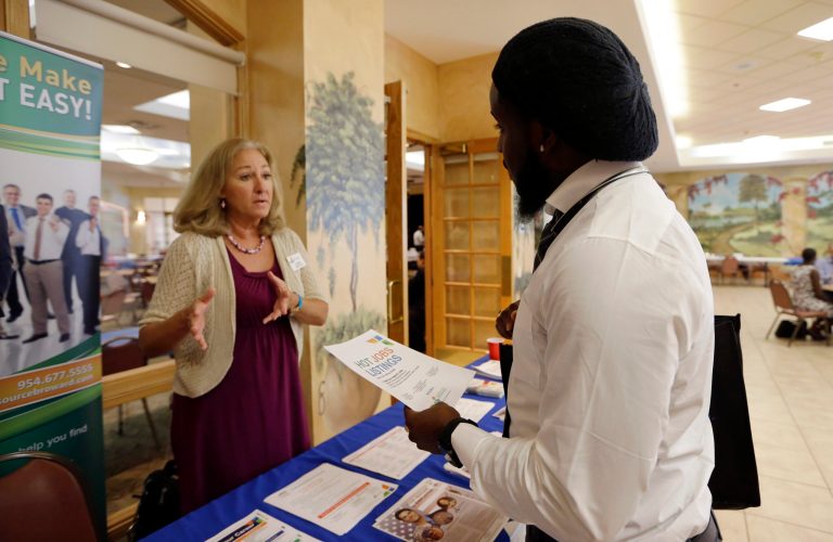 In this Oct. 6, 2015, photo, military veteran Mark Cannon, of Miami, right, talks with Cynthia Carcillo, a veterans outreach representative for Career Source Broward, about employment opportunities at a job fair for veterans, in Pembroke Pines, Fla. The Labor Department reported Thursday, Nov. 19, 2015, that fewer Americans sought unemployment aid a week earlier, fresh evidence that companies are confident enough in the economy to hold onto their workers. (AP Photo/Lynne Sladky)