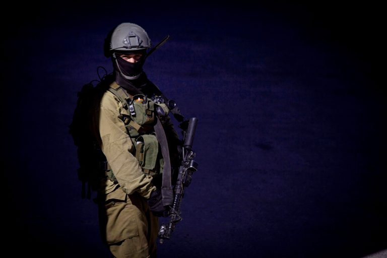 An Israeli soldier stands guard in the West Bank City of Hebron, Saturday, June 14, 2014. Israeli security forces searched the West Bank for a second day Saturday, looking for three missing teenagers, including a U.S. citizen, who they fear have been abducted by Palestinian militants. (AP Photo/Majdi Mohammed)