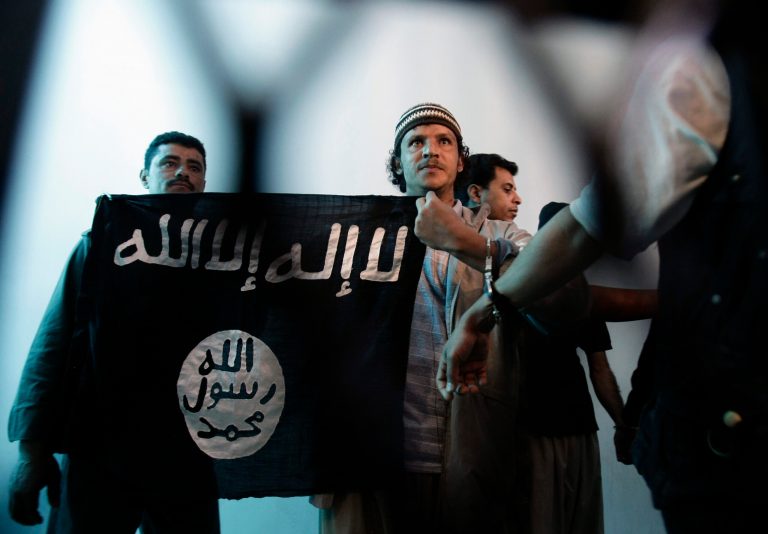 A suspected Yemeni al Qaeda militant, center, holds an Islamist banner in Sanaa, Yemen. Al Qaeda in the Arabian Peninsula has been the most active of the terror network's branches in trying to strike in the West. (AP Photo/Hani Mohammed)