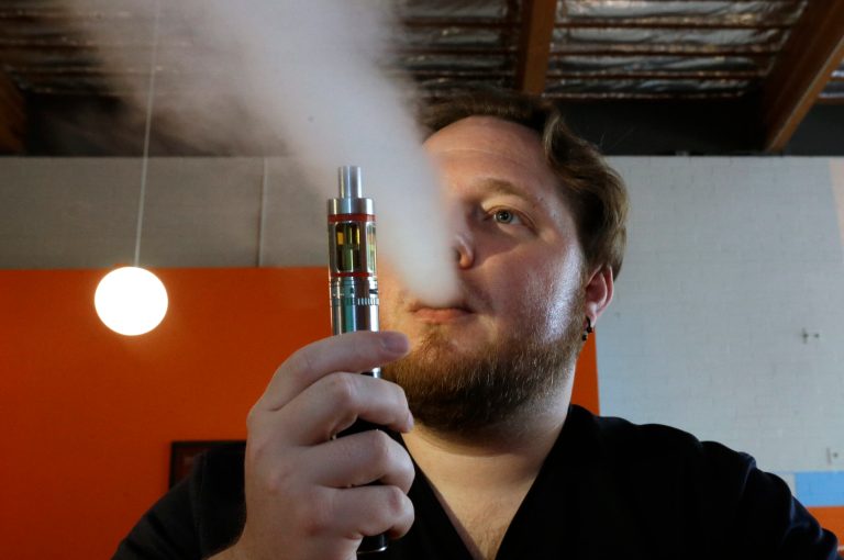 Bruce Schillin, 32, exhales vapor from an e-cigarette in Sacramento, Calif. In 2015, the rate of smoking among adults in the U.S. fell to 15 percent. The increased popularity of electronic cigarettes has likely played a role. (AP Photo/Rich Pedroncelli)