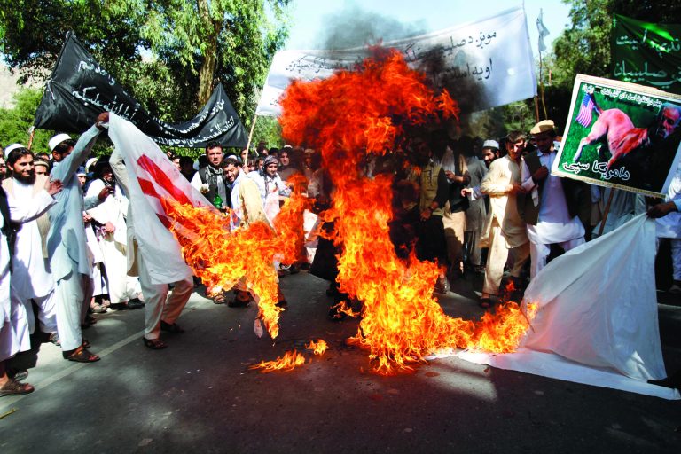 Afghan university students burn a U.S. flag in Surkhrod district of Nangarhar province, east of Kabul, Afghanistan, Wednesday, Sept 19, 2012. Hundreds of Afghans, some shouting 