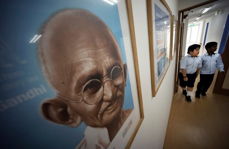 Indian and Japanese students walk together near a portrait of Mahatma Gandhi at Global Indian International School in Tokyo Friday, Aug. 29, 2014. Japan and India both have much to gain from a visit by Indian Prime Minister Narendra Modi and more than a dozen Indian steel, energy and IT tycoons that begins Saturday in the ancient capital of Kyoto. (AP Photo/Eugene Hoshiko)