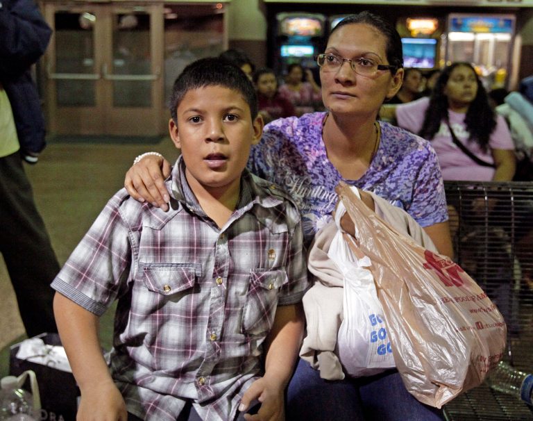 Maria Eva Casco, left, and her son Christian Casco, of El Salvador, sit at at the Greyhound bus terminal in Phoenix last month. Central American families arrested in Texas will continue to be flown to Arizona, and hundreds of unaccompanied minors a day are being shipped to a federal detention center in the southern part of the state, Gov. Jan Brewer's spokesman says. (AP Photo/Rick Scuteri)