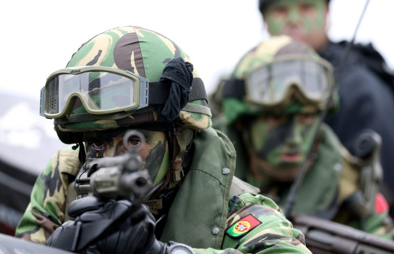 A portuguese fuzileiro, stands guard on a boat prior to the NATO Trident Juncture exercise 2015 in Troia, south of Lisbon, Thursday, Nov. 5, 2015. NATO Allies and partner nations join forces during three weeks for the Alliance's Trident Juncture live military exercise involving 36,000 troops from more than 30 nations across Portugal, Italy and Spain. (AP Photo/Steven Governo)
