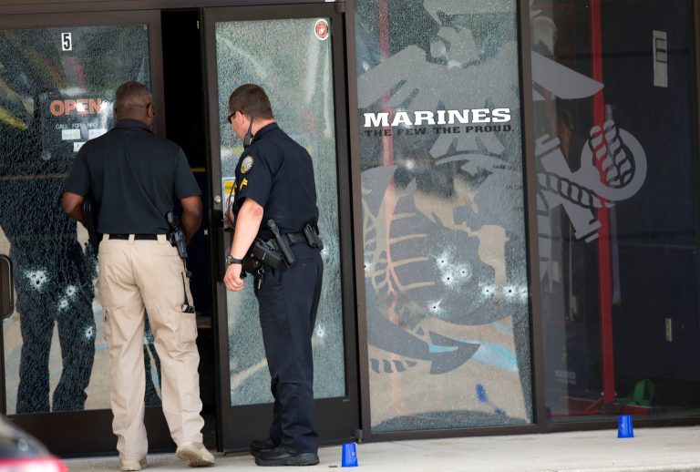 Police officers enter the Armed Forces Career Center through a bullet-riddled door after a gunman opened fire on the building Thursday, July 16, 2015, in Chattanooga, Tenn. Authorities say there were multiple casualties including the gunman. (AP Photo/John Bazemore)