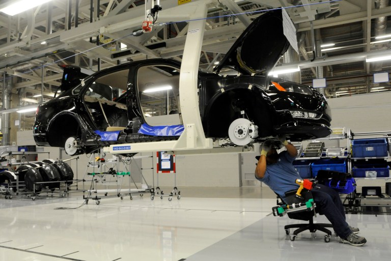 Workers inspect the undercarriage of a new Passat inside the new Volkswagen plant in Chattanooga, Tenn., Wednesday. May 24, 2011. (AP Photo/Billy Weeks)