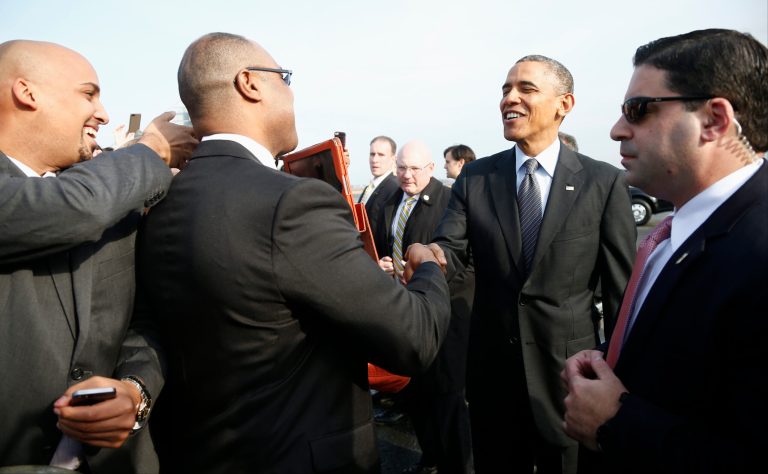 President Barack Obama is greeted by well-wishers as he arrives at Boston Logan Airport, Wednesday, Oct. 30, 2013, before going to Faneuil Hall to speak about the federal health care law. Faneuil Hall is where former Massachusetts Gov. Mitt Romney, Obama's rival in the 2012 presidential election, signed the state's landmark health care law in 2006, with top Democrats standing by his side. (AP Photo/Charles Dharapak)