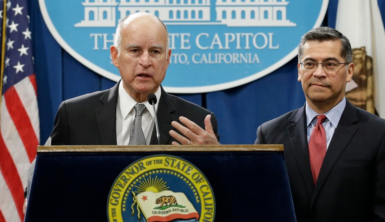 The Department of Justice filed the lawsuit Tuesday in a federal district court in Sacramento over three separate states government's' immigration policies. California Gov. Jerry Brown, left, and California Attorney General Xavier Becerra appeared together in Sacramento following the announcement of the lawsuit. (AP Photo/Rich Pedroncelli)