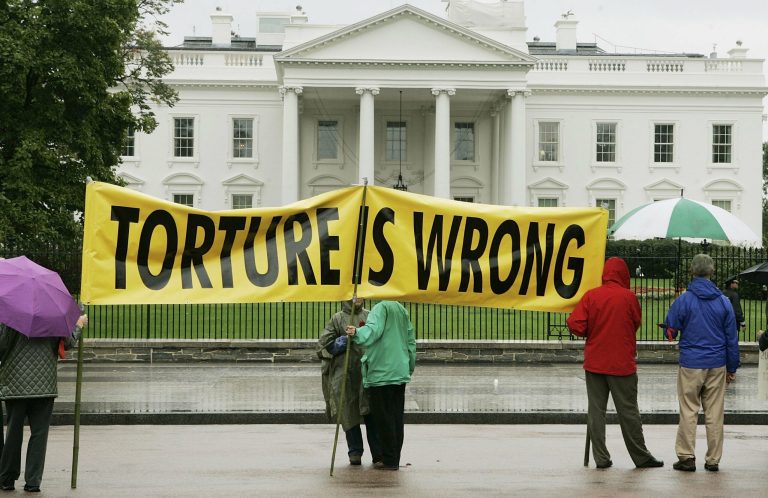 Protesters display a banner that says 