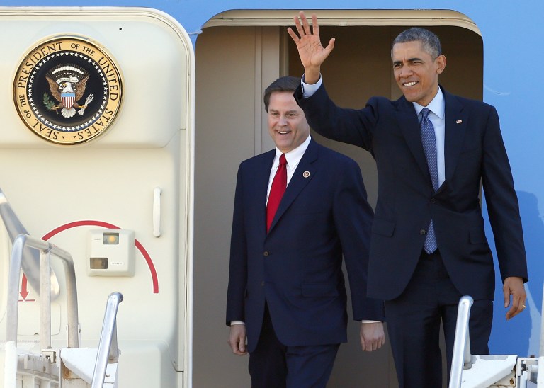 President Obama, accompanied by Rep. Donald Norcross, D-N.J., waves as they walk off Air Force One at Joint Base McGuire-Dix in Wrightstown, N.J. Monday, Dec. 15, 2014. (AP Photo/Rich Schultz)