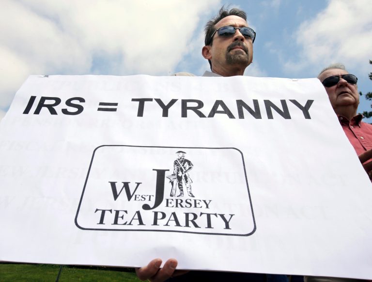 Keith Peacock, of Hainesport, holds a sign during a tea party rally protesting extra IRS scrutiny of their groups in the IRS scandal of 2013. (AP Photo/Mel Evans)