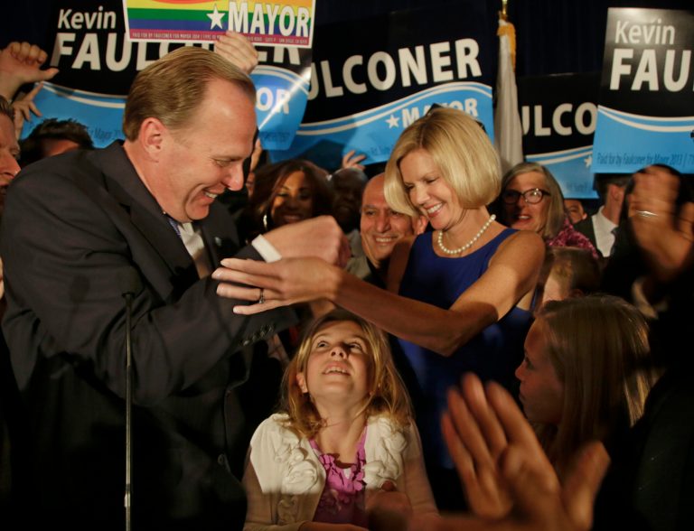 San Diego mayoral candidate Kevin Faulconer reaches for his wife, Katherine, as their daughter looks up from below after Faulconer addressed his supporters at a rally Tuesda in San Diego. (AP/Lenny Ignelzi)