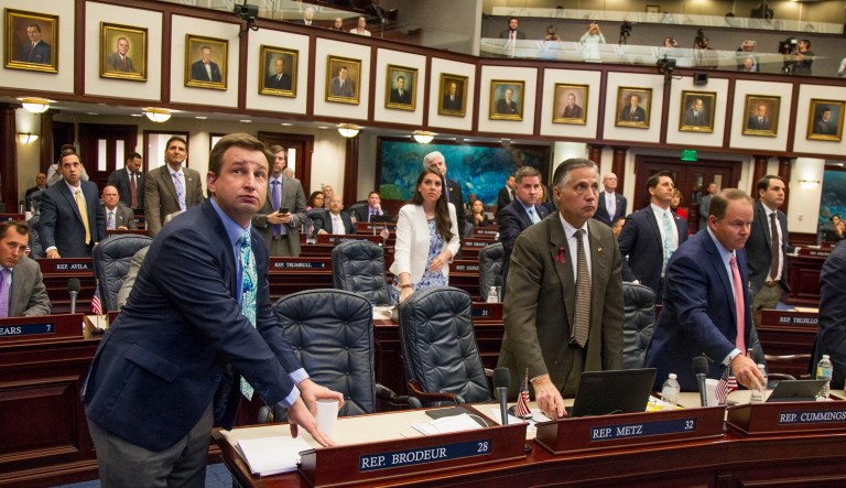 Florida Rep. Jason Brodeur, left, (R- Sanford), watches the vote board as he votes on the school safety bill which passed the House 67-50 at the Florida Capital in Tallahassee, Fla., on Wednesday. (AP Photo/Mark Wallheiser)